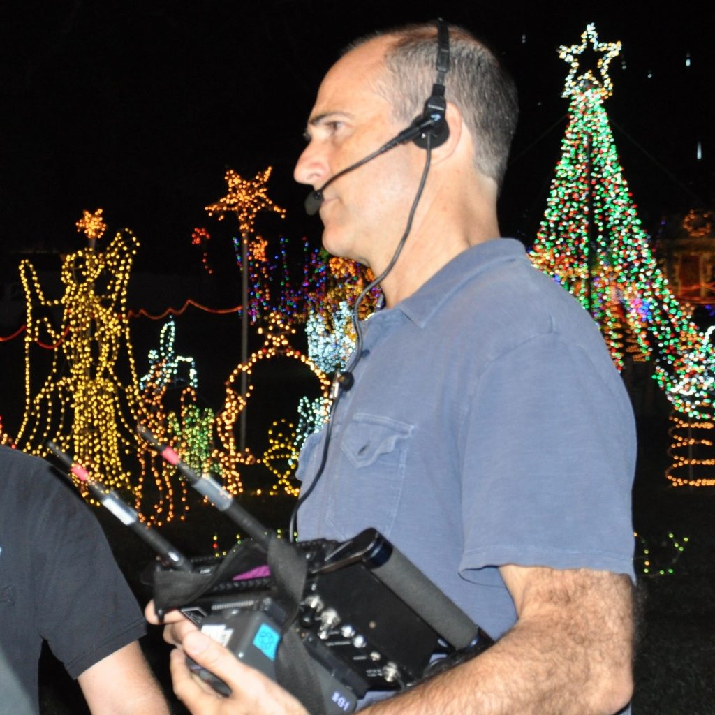 Brady directing with headset and equipment in hand.