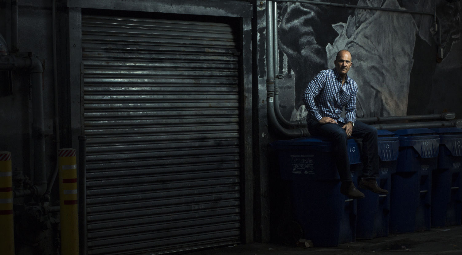 Brady Connell night shot in alley sitting on a trash can